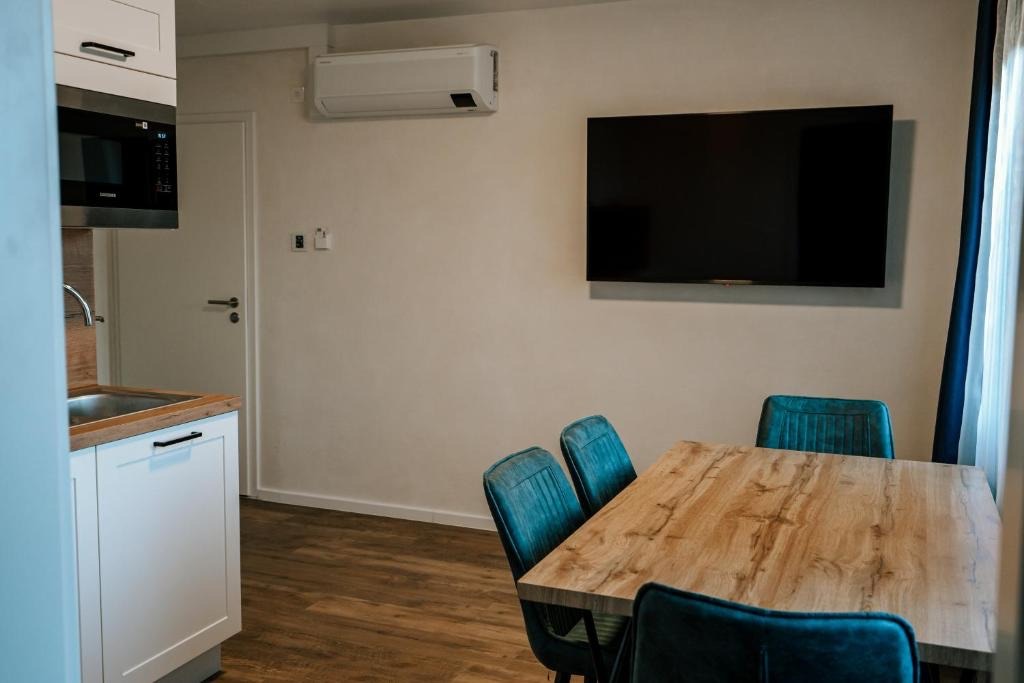 Wohn- und Essbereich eines Apartments im dillhotel Ilsede mit Küchenzeile, Fernseher und Esstisch
