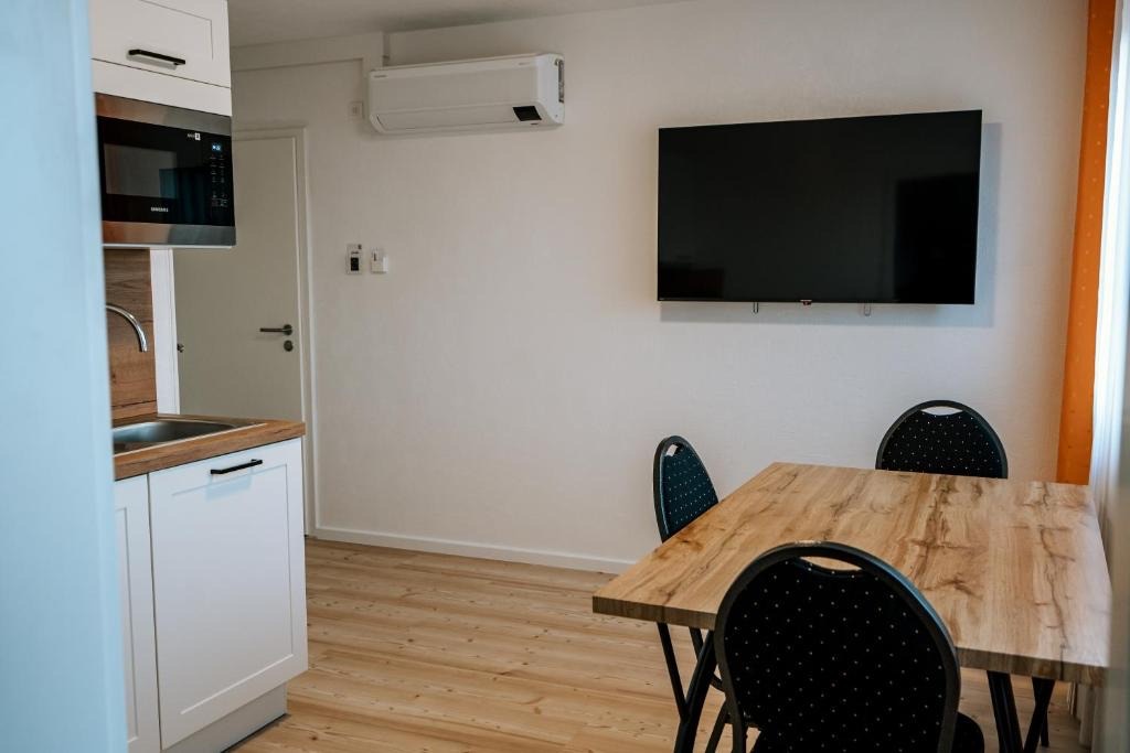 Küchenzeile mit Essplatz und Fernseher in einem Apartment des dillhotel Ilsede