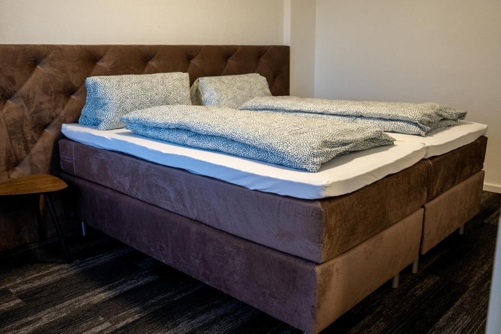 Zwei zusammengestellte Einzelbetten mit gepolstertem Kopfteil in einem Apartment des dillhotel