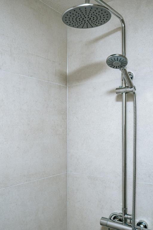 Bodengleiche Dusche mit Regenduschkopf im Bad eines Apartments des dillhotel