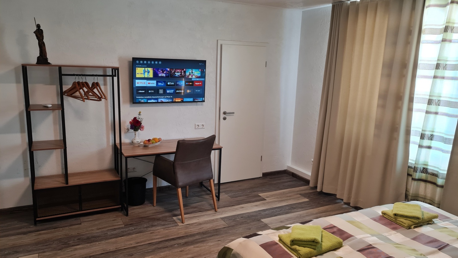 Blick vom Fenster auf Bett und Sofa in Zimmer 6