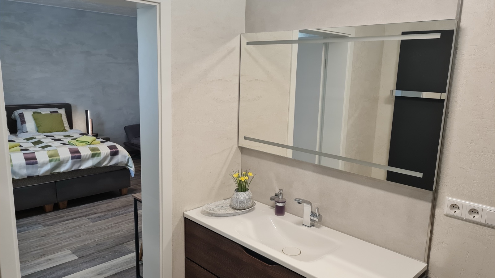 Waschbecken mit großem Spiegel im Bad von Zimmer 6