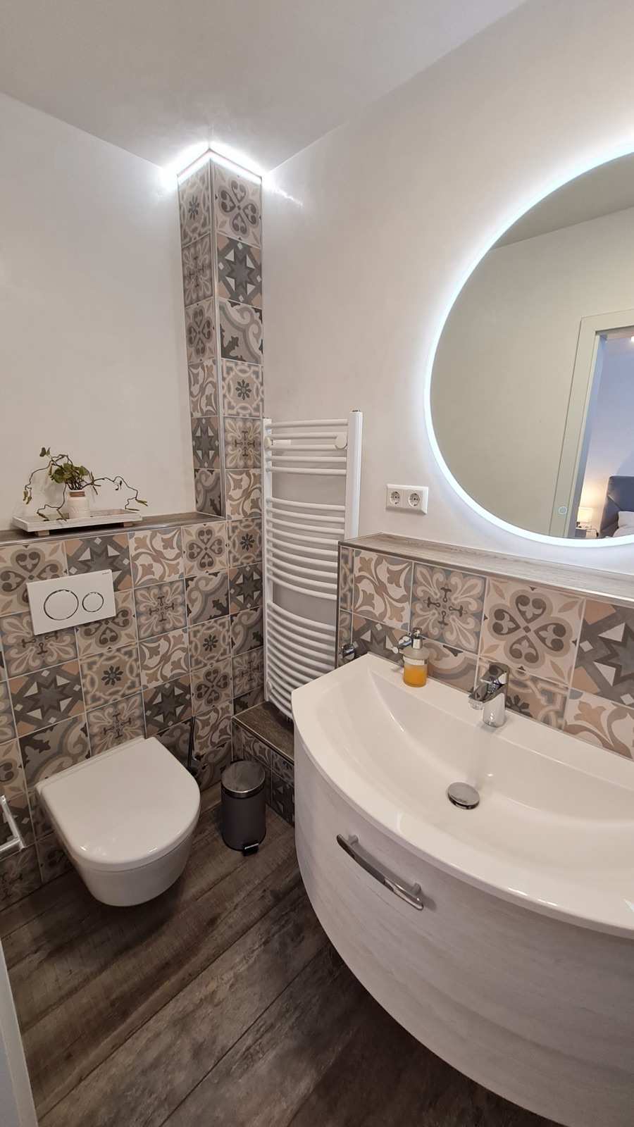 Badezimmer mit rundem Spiegel und Waschbecken in Zimmer 7