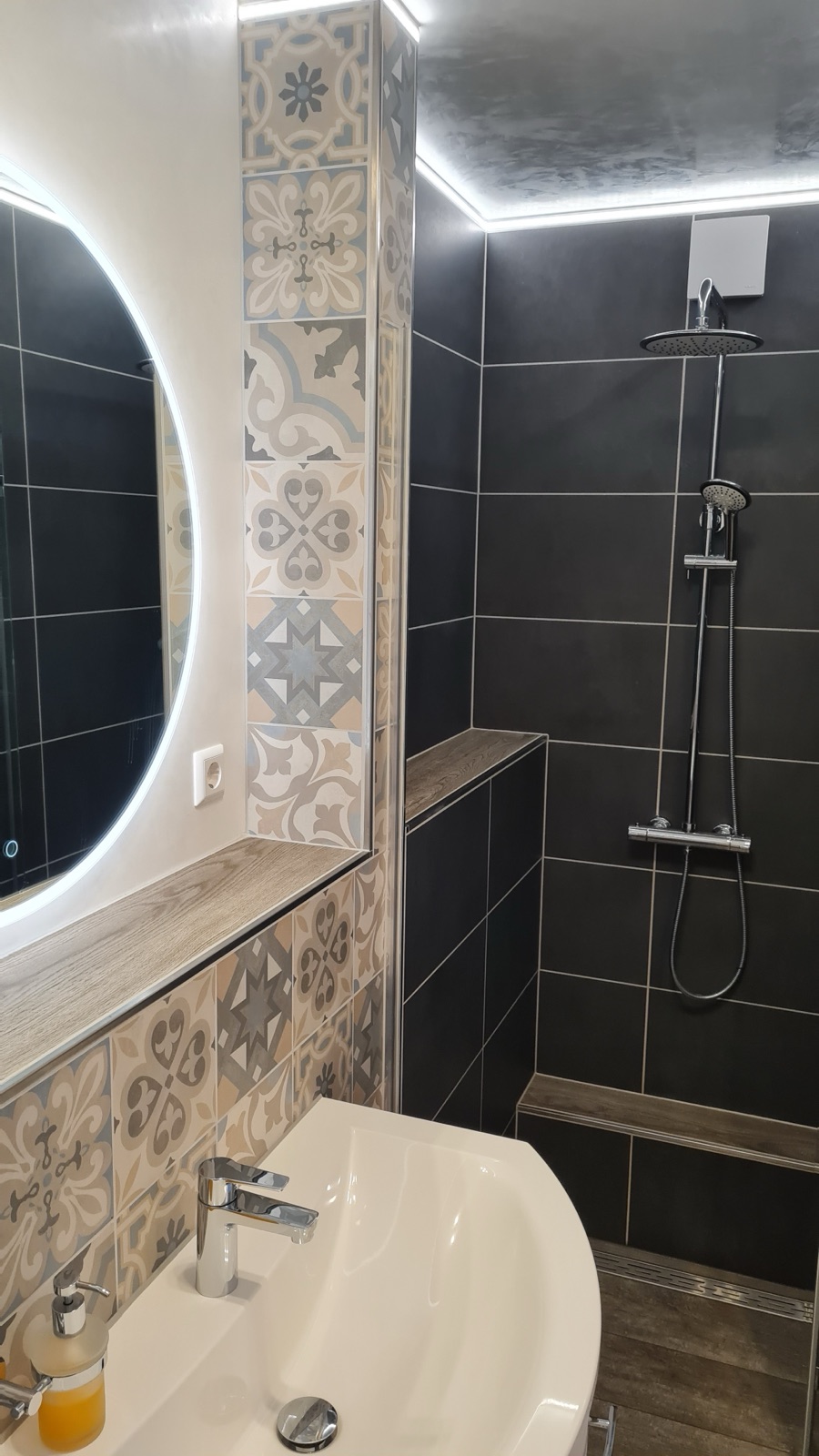 Dusche mit dunklen Fliesen im Bad von Zimmer 7