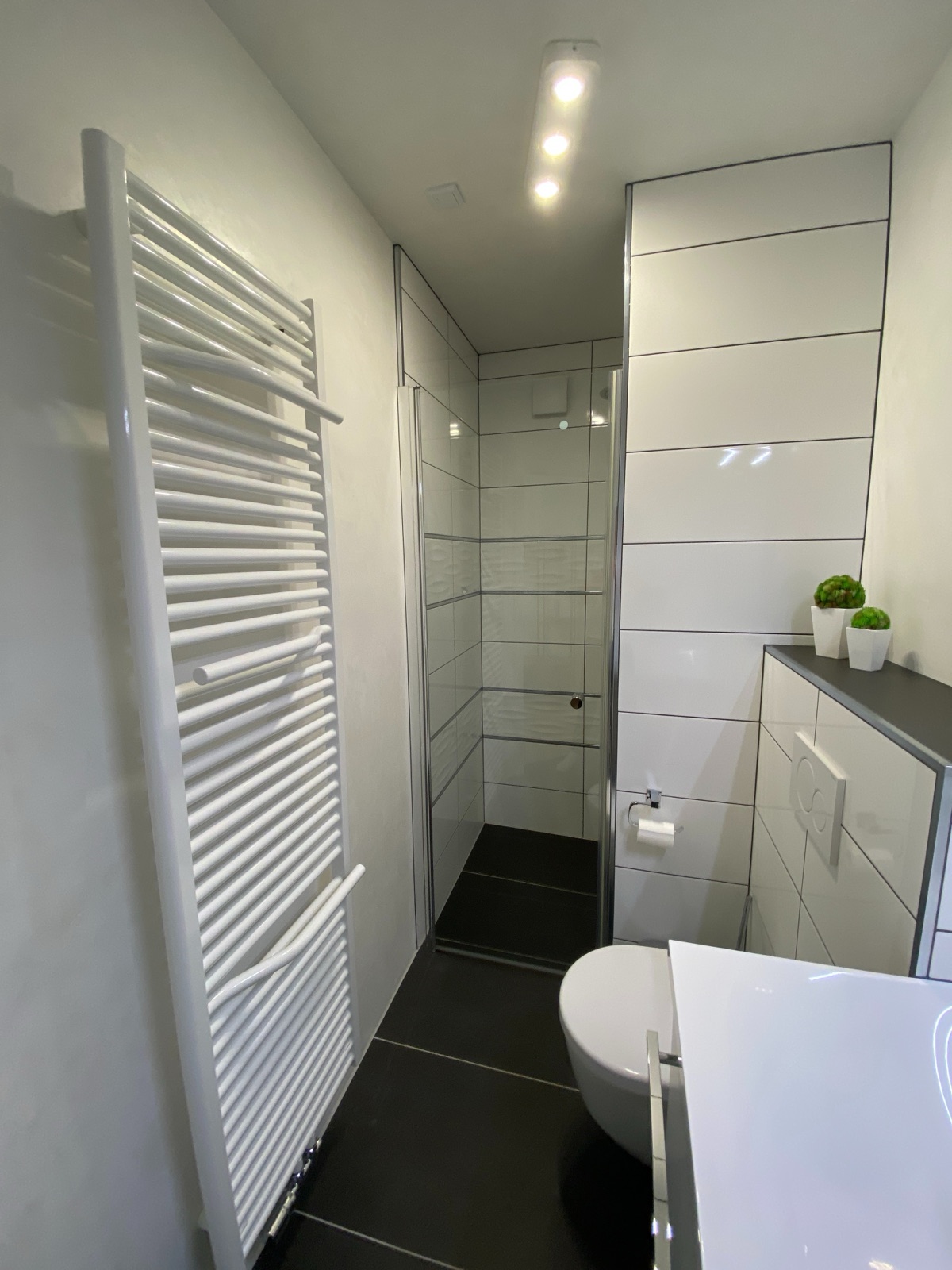 Eigenes Bad mit Dusche und Handtuchheizkörper in Zimmer 8