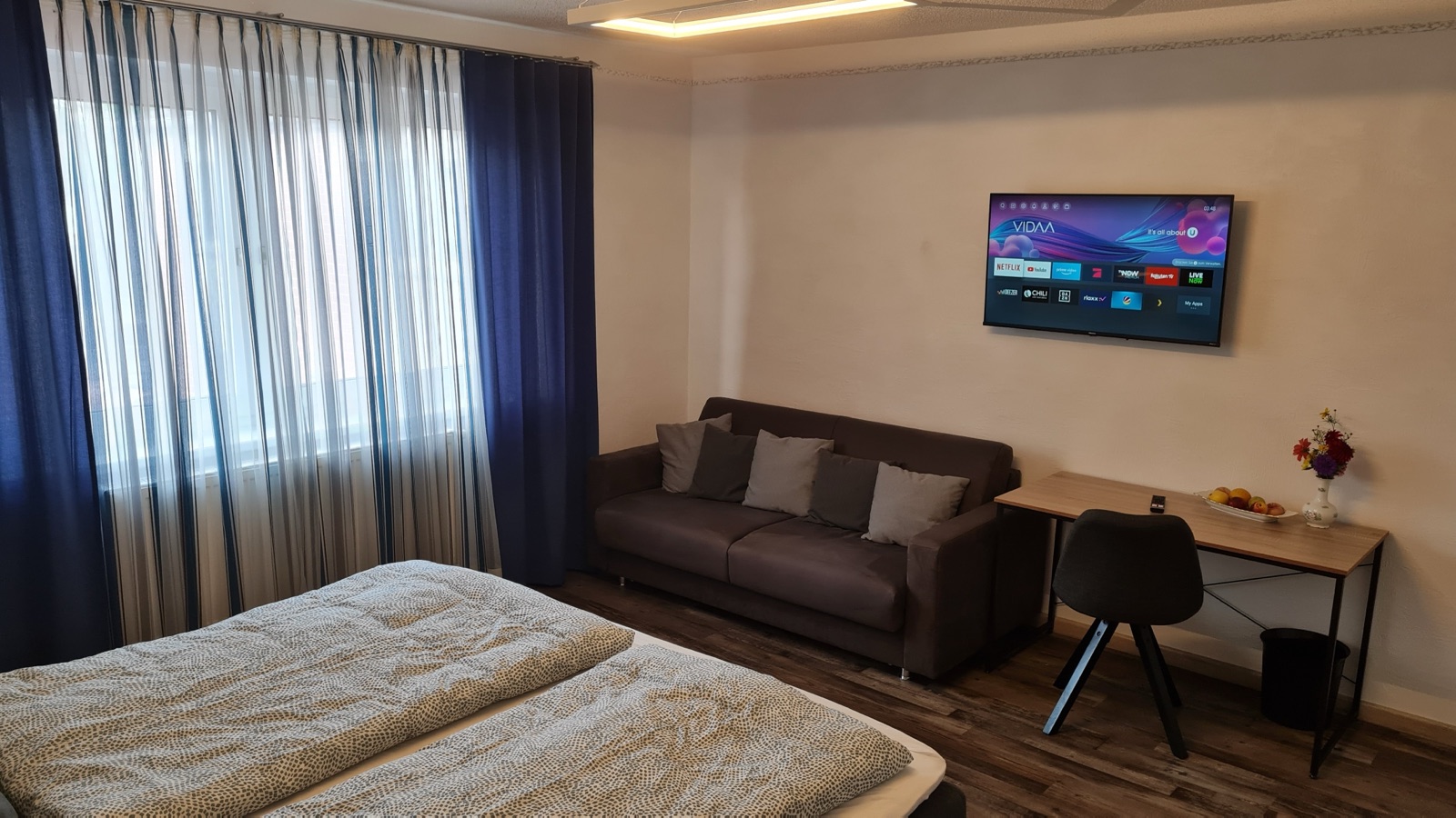 Sofa, Tisch und Fernseher im Wohnbereich von Zimmer 9