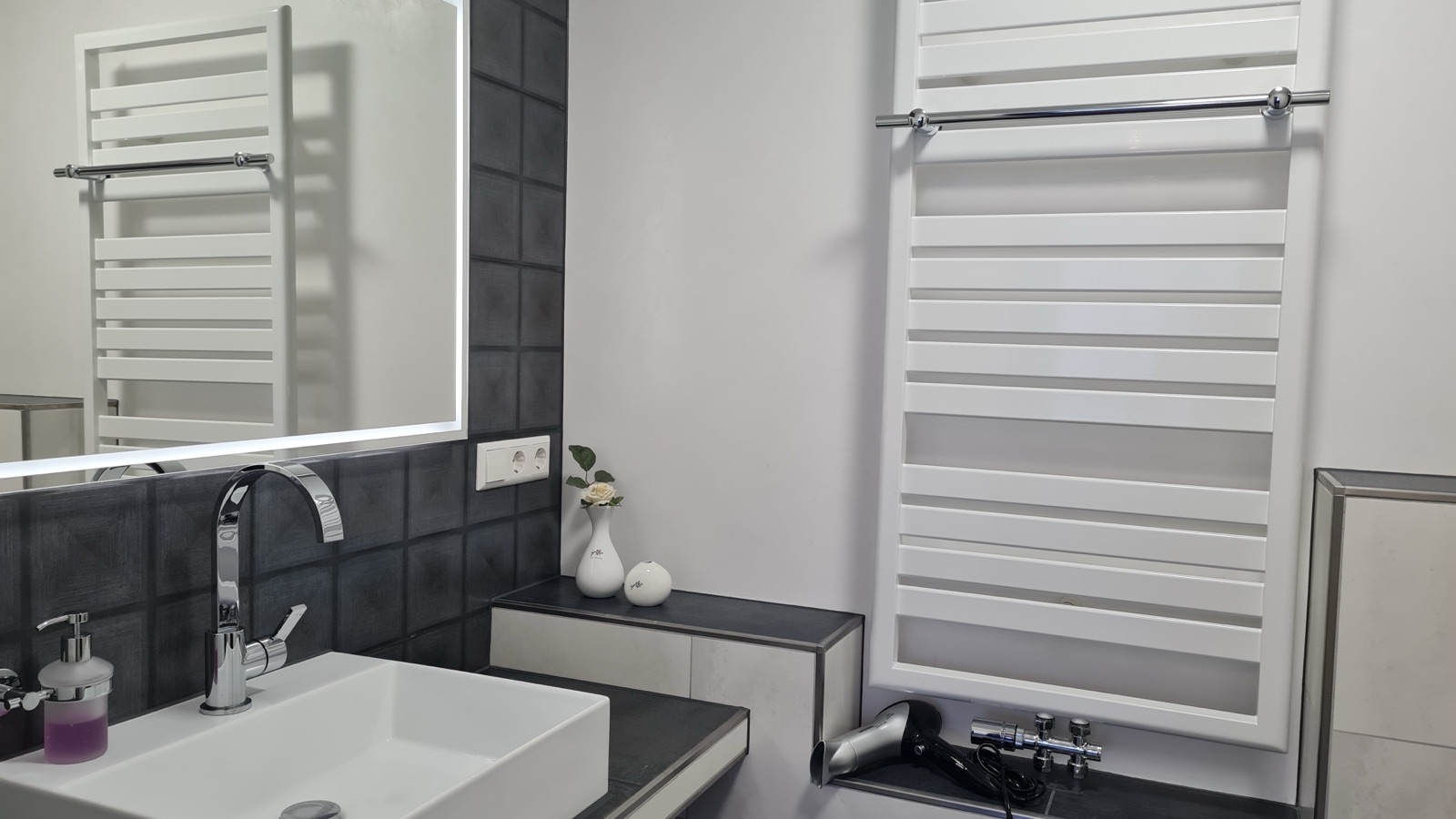 Waschbecken und Handtuchheizkörper im Bad von Zimmer 9